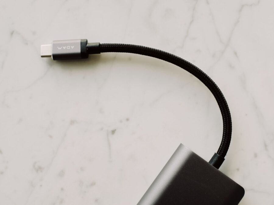 Detalhe da porta USB-C recebendo energia de power bank para notebook