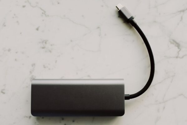 Power bank para notebook de alta potência carregando laptop pela porta USB-C sobre a mesa