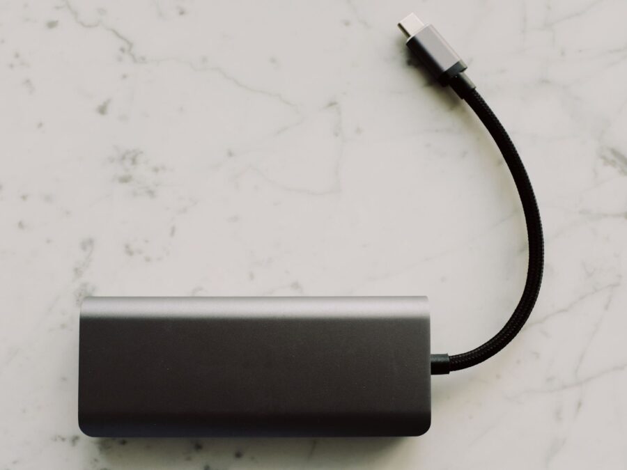 Power bank para notebook de alta potência carregando laptop pela porta USB-C sobre a mesa