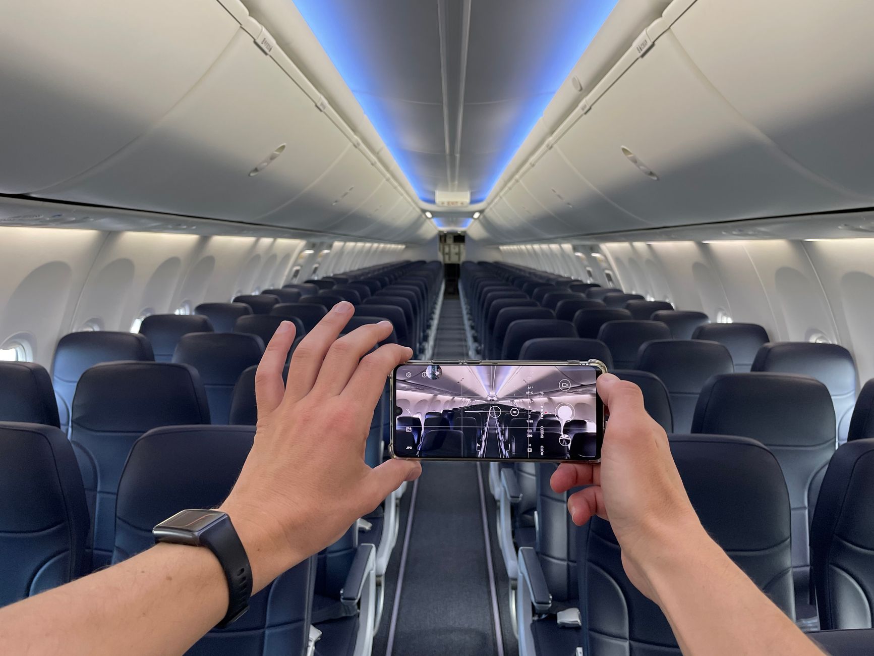 Mochila de viagem com dispositivos eletrônicos e power bank para notebook na poltrona do avião